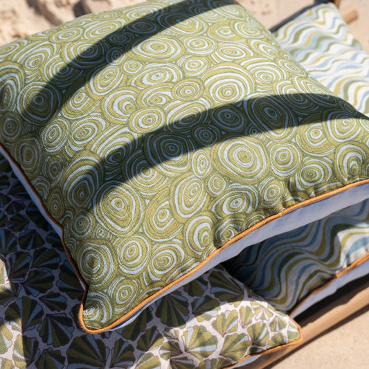 Growth Rings linen cushion cover in green and natural tones styled with coordinating coastal cushions