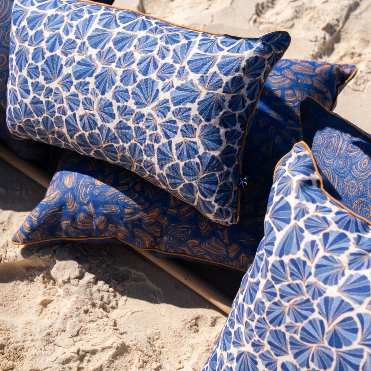 Mariner Shells linen cushion cover styled with coordinating Mariner cushions on the beach