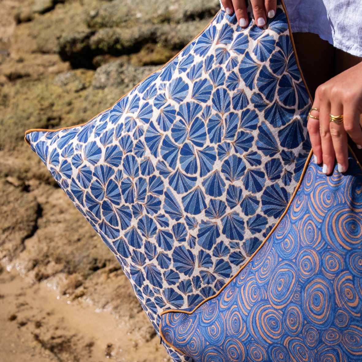 Close-up of Mariner Shells linen cushion cover showing blue shell print and ochre piping