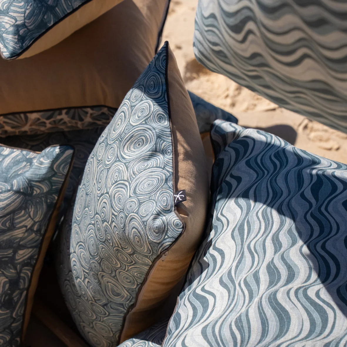 Close-up of Frenchmans linen cushion covers showing Straddie Stripe, Growth Rings and Pipi designs.