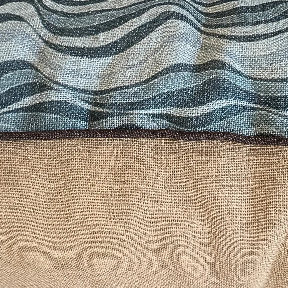 Detail of Frenchmans Straddie Stripe linen cushion showing the blue wave print, piping and natural linen backing.