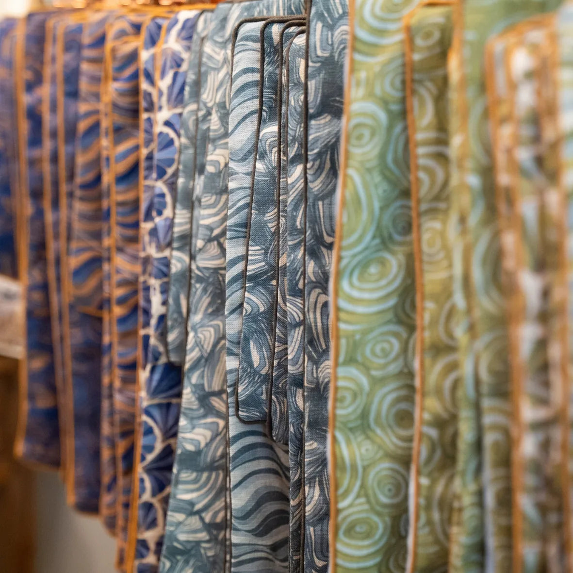 Starfish Studio linen cushion covers displayed in-store, showing Pipi and coordinating coastal prints in green and blue tones.