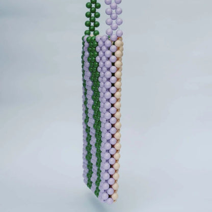 Three beaded necklaces in green, purple, and beige on a light gray background
