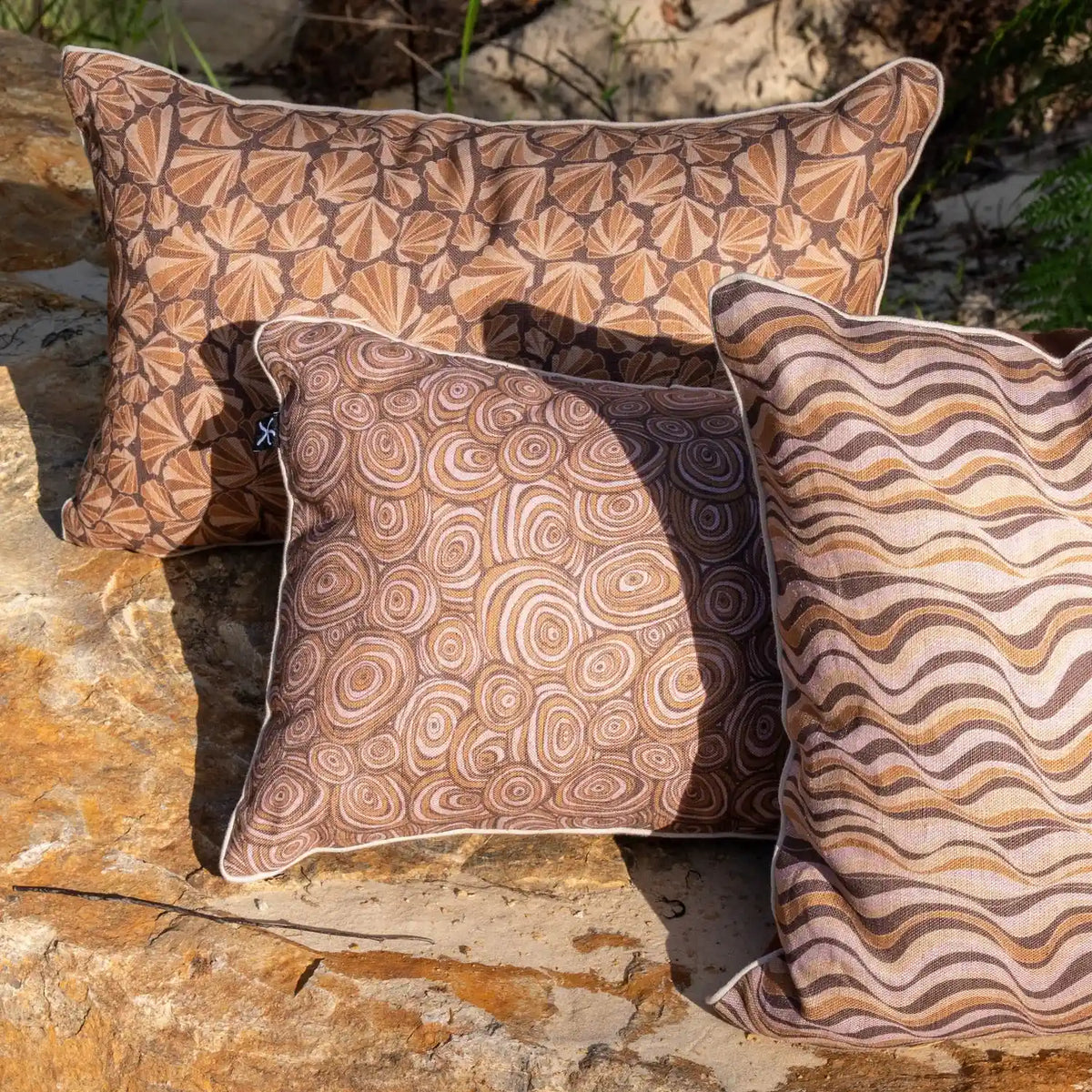Claytons Growth Rings linen cushion cover styled outdoors with coordinating Claytons coastal cushion prints