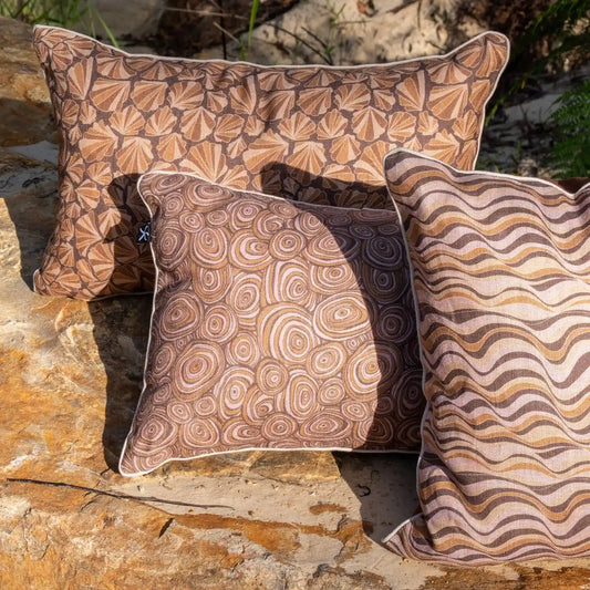 Claytons Growth Rings linen cushion cover styled outdoors with coordinating Claytons coastal cushion prints