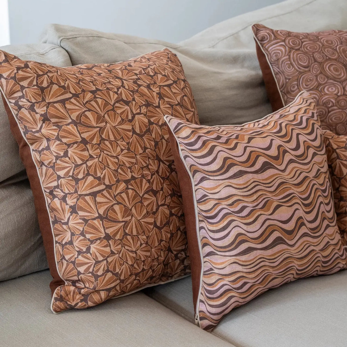 Claytons Straddie Stripe linen cushion styled on a lounge with Claytons Shells and Growth Rings cushions