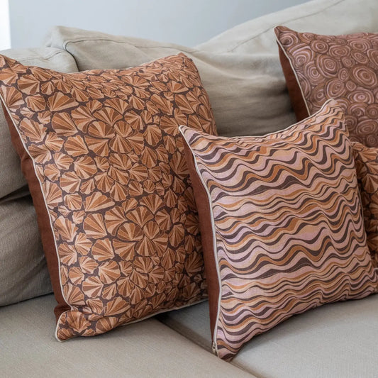 Claytons Straddie Stripe linen cushion styled on a lounge with Claytons Shells and Growth Rings cushions