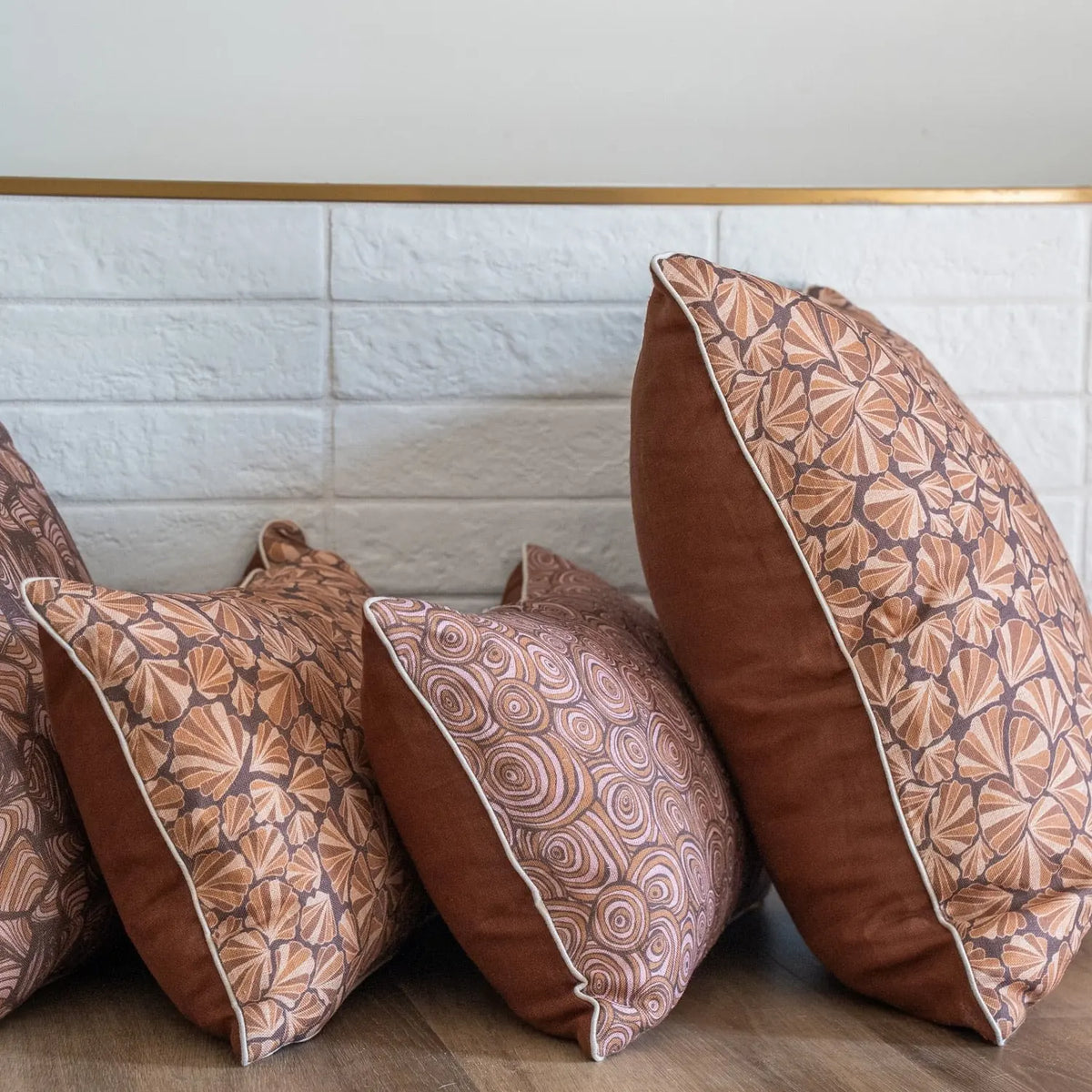 Claytons Shells linen cushions styled side-on with coordinating brown reverse and Growth Rings cushion
