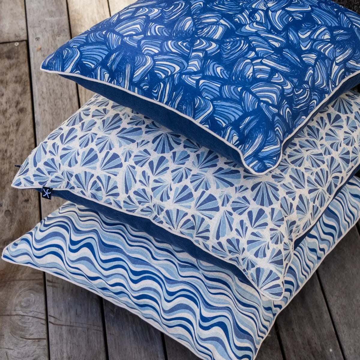 Pacific Shells linen cushion cover stacked with Pipi and Straddie Stripe coastal cushions
