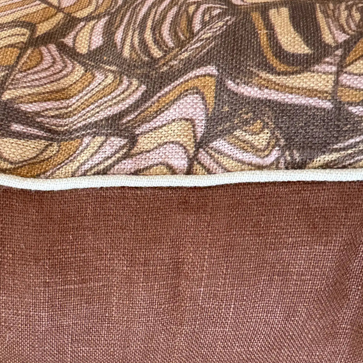 Close-up of Claytons Pipi linen cushion cover showing printed fabric, natural piping and warm brown reverse
