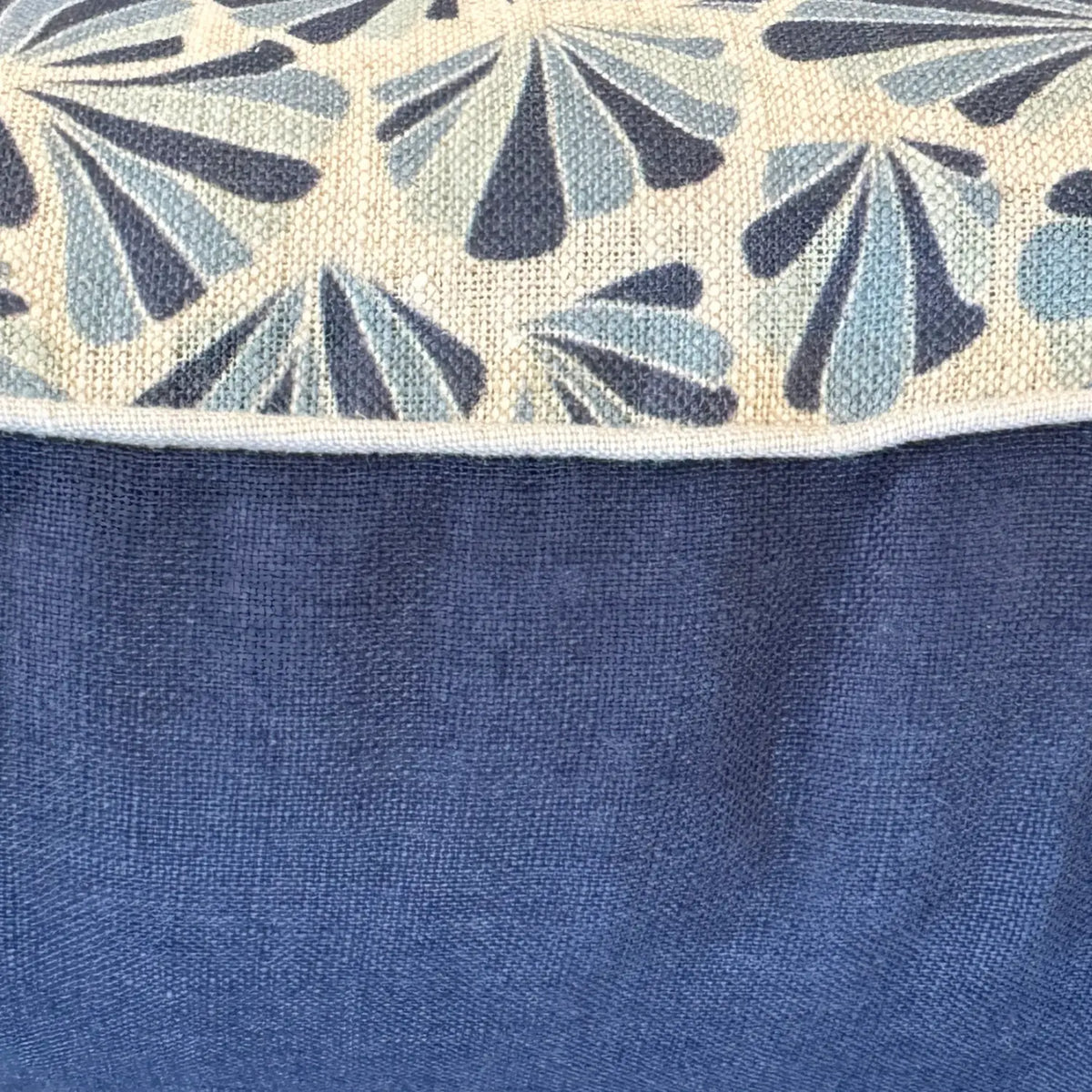 Close-up of Pacific Shells linen cushion cover showing blue shell print, natural piping and navy reverse