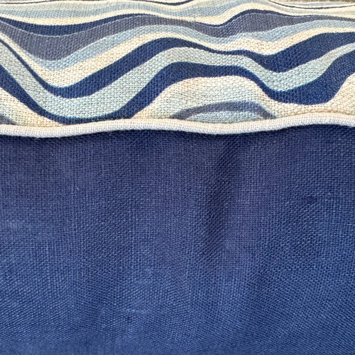 Close-up of Pacific Straddie Stripe linen cushion cover showing wave print, natural piping and navy reverse