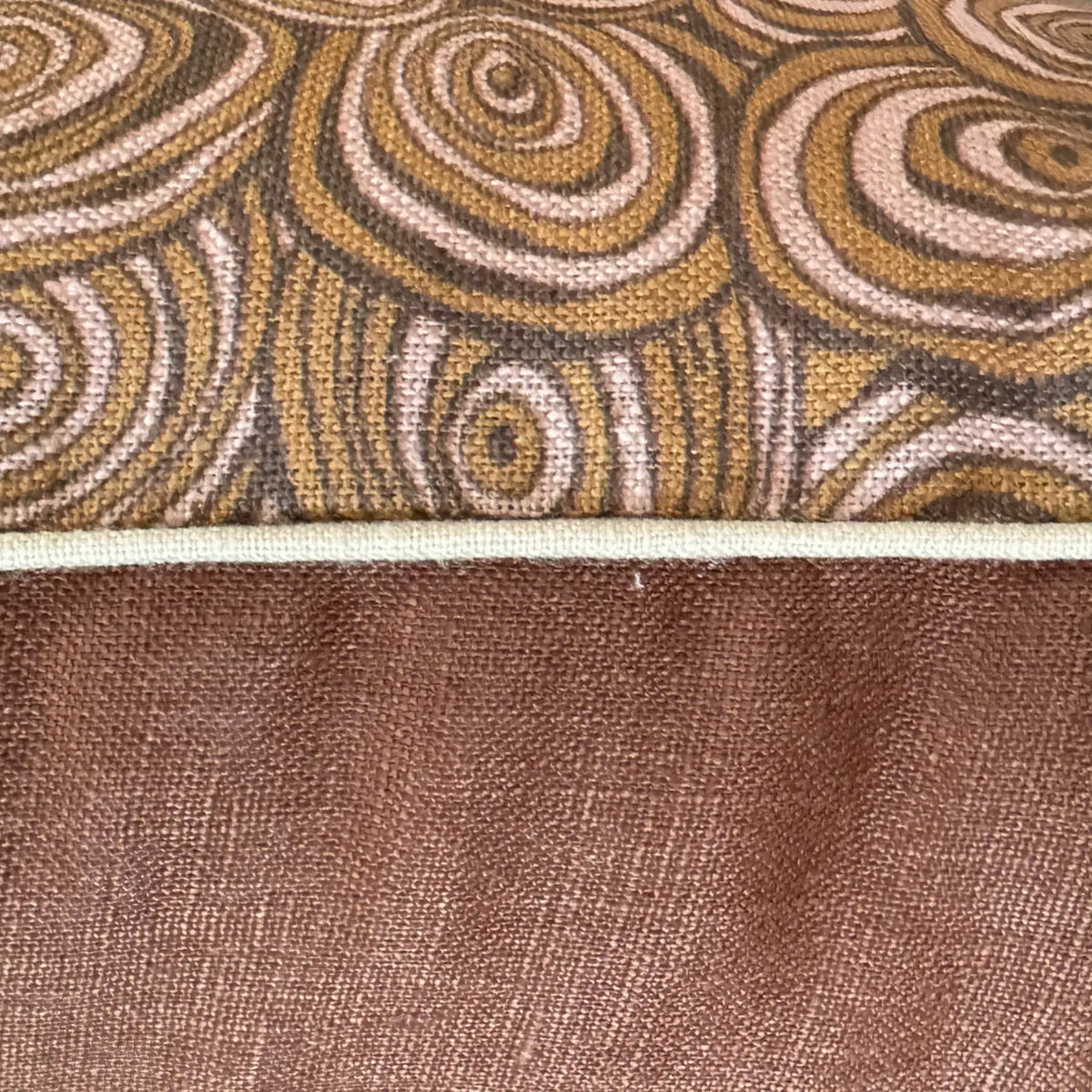 Close-up of Claytons Growth Rings linen cushion cover showing printed fabric, natural piping and brown reverse