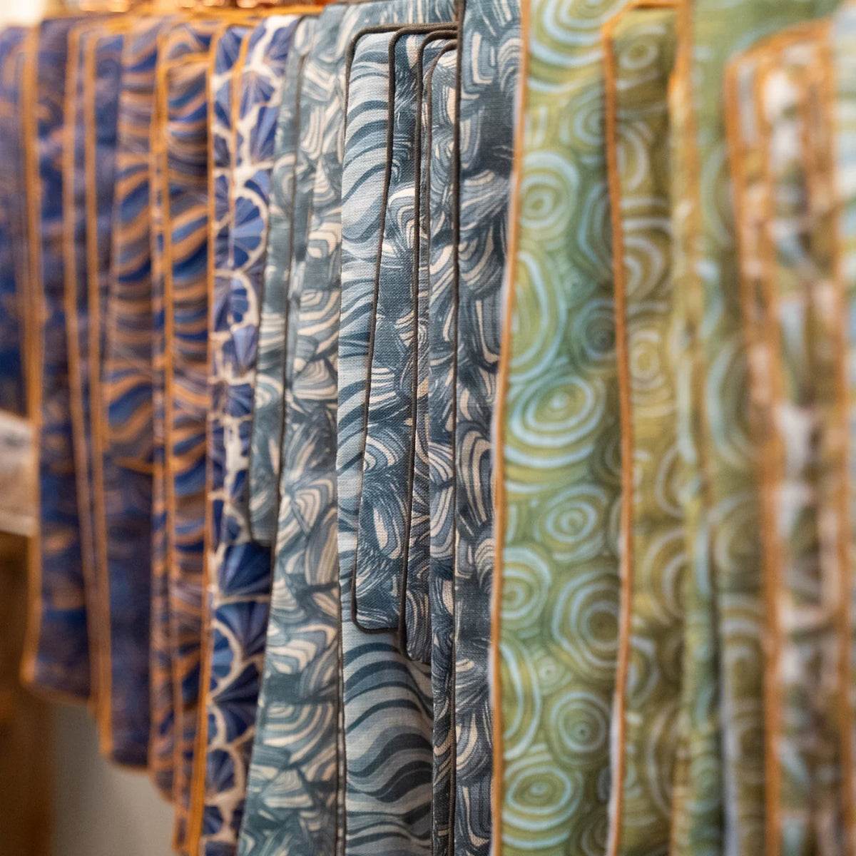 Starfish Studio linen cushion covers in blue and green coastal prints displayed in store