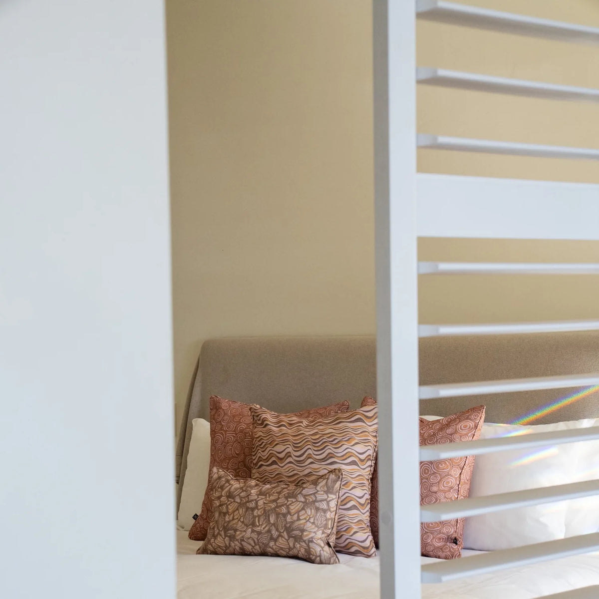 Claytons colourway cushions featuring Growth Rings, Straddie Stripe and Pipi patterns styled together on a bed.