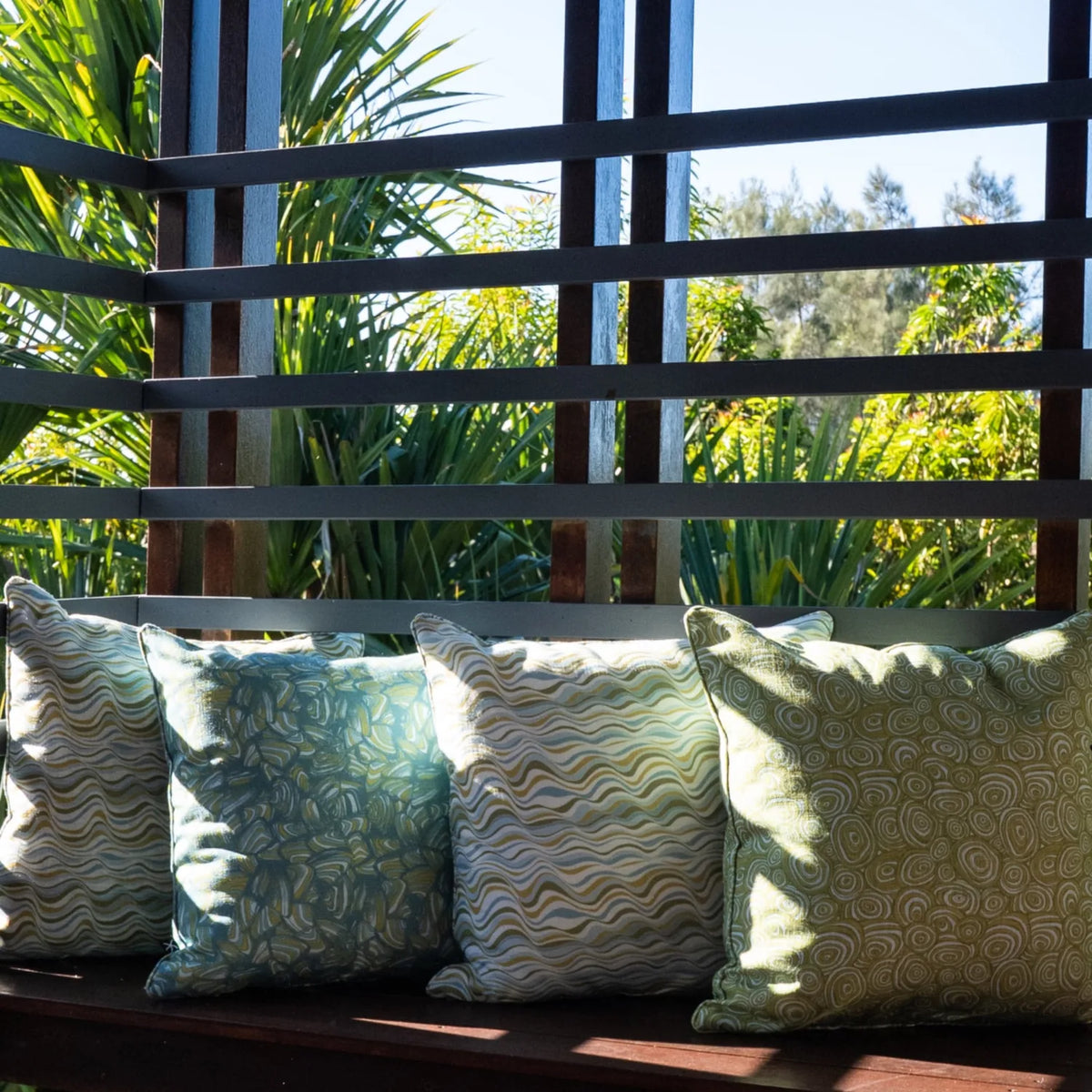 Mangrove cushion collection styled along an outdoor timber bench with mixed prints
