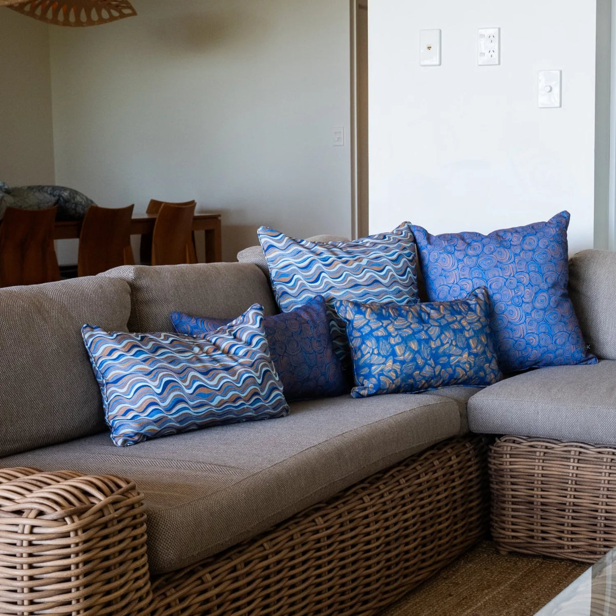 Mariner cushion collection styled on a woven lounge with Straddie Stripe, Growth Rings and Pipi prints.