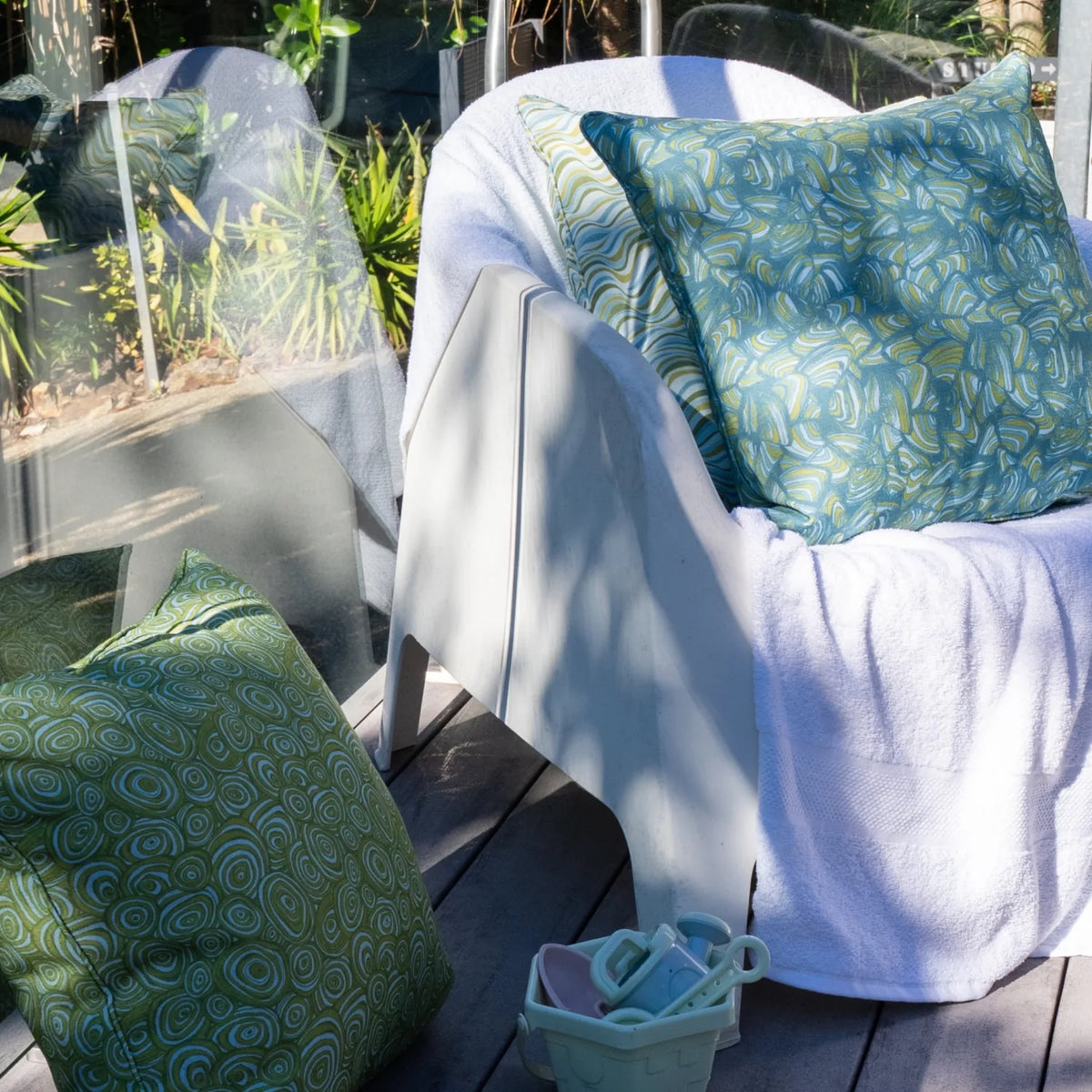 Mangrove outdoor cushions styled on poolside chairs with children’s beach toys nearby.