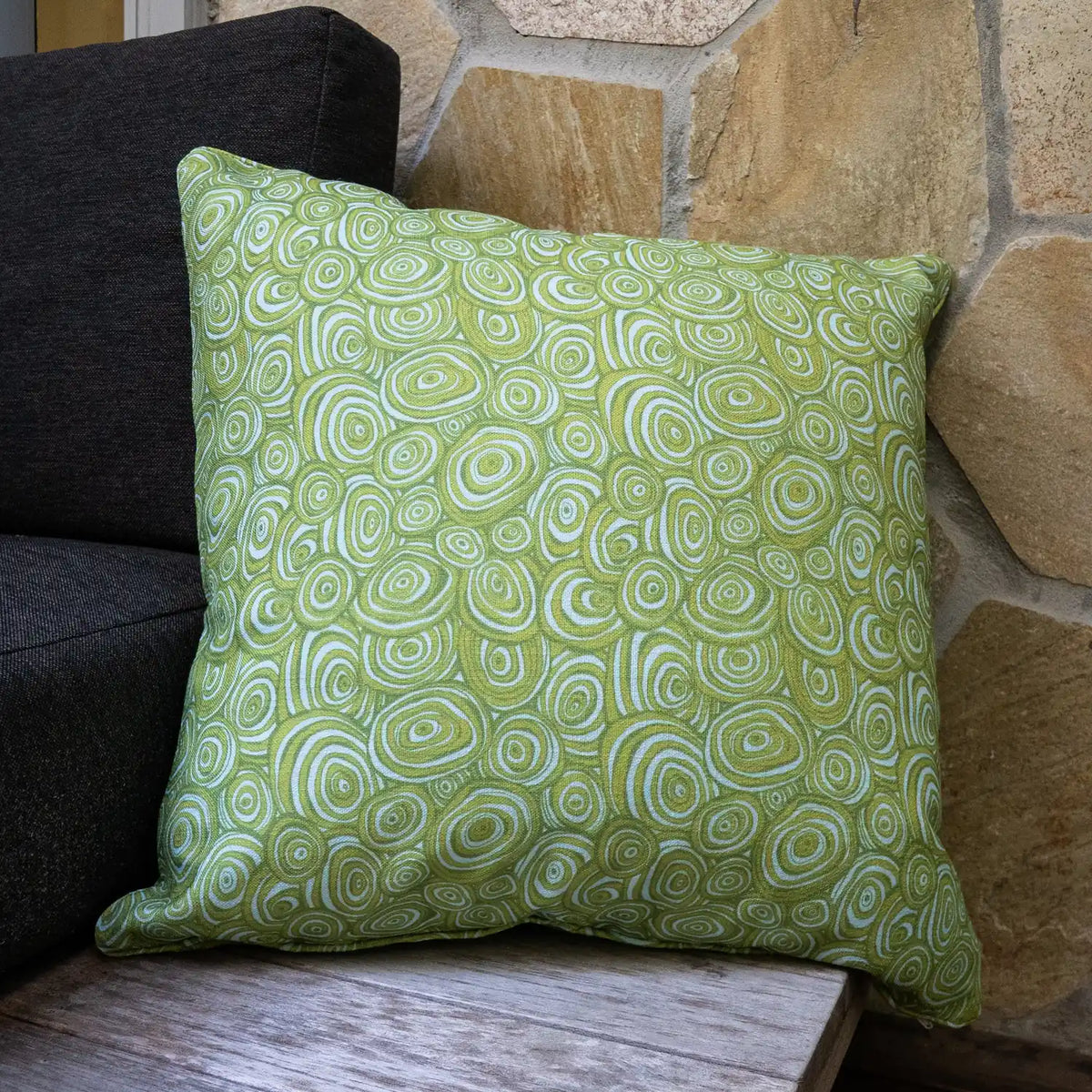 Outdoor Indoor Growth Rings cushion cover in Mangrove, square cushion, on a stone wall bench