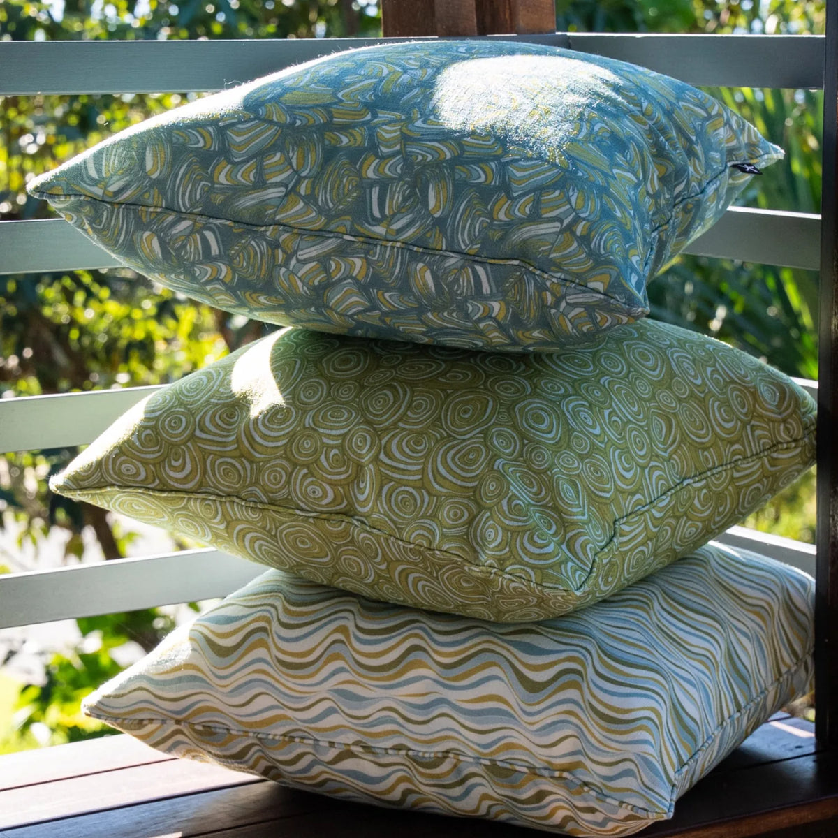Mangrove colourway outdoor indoor cushion covers stacked together, featuring Straddie Stripe with coordinating Pipi and Growth Rings prints.