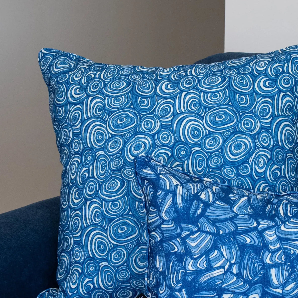 Ocean Growth Rings outdoor indoor cushion cover in blue shown close up with a coordinating Ocean print cushion.