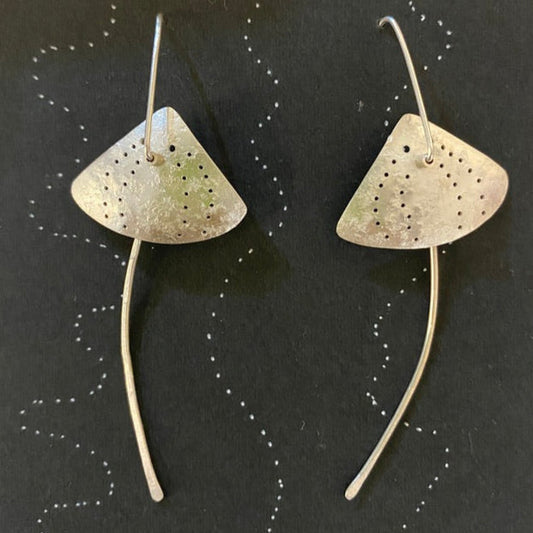 Pair of silver stingray earrings earrings on a black card with white speckles